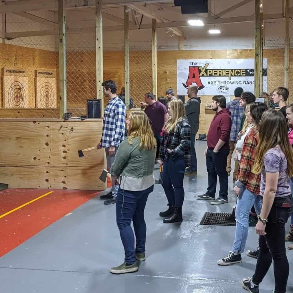 people at an indoor axe throwing event