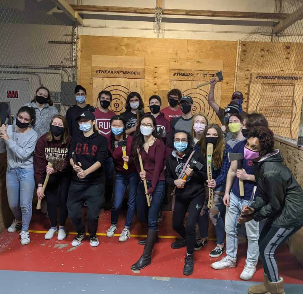 IUP students posing at an indoor axe throwing lane