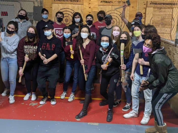 IUP students posing at an indoor axe throwing lane