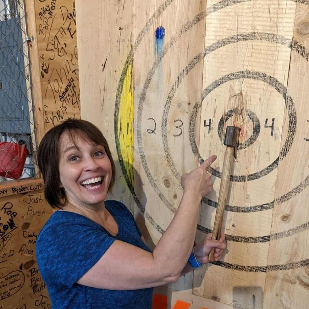 woman showing off her axe throwing bullseye