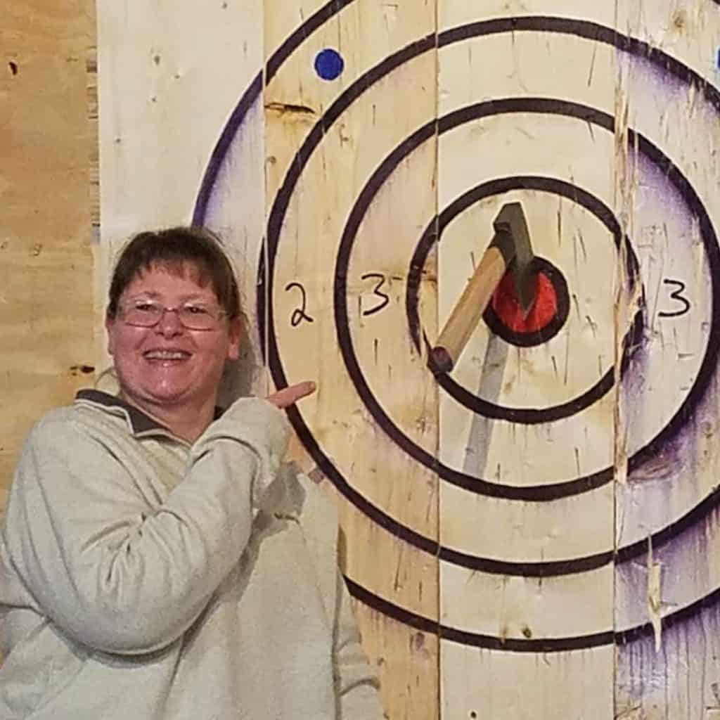 woman showing off her axe throwing bullseye