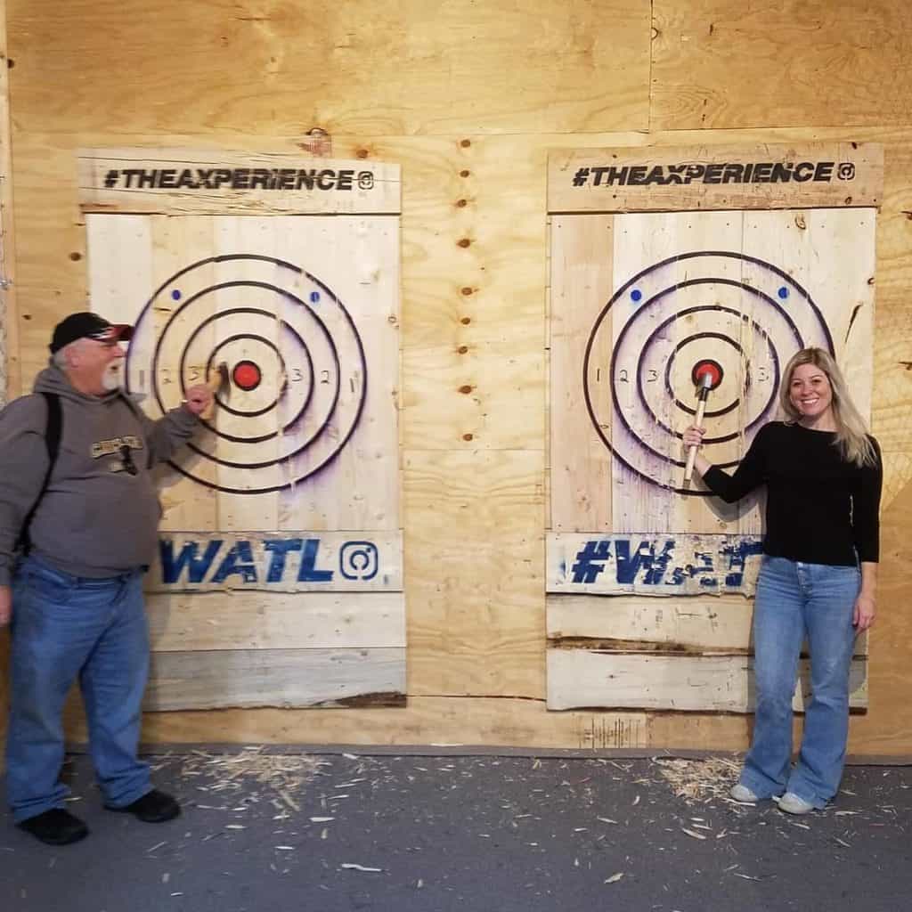 man and woman showing off their axe throwing skills