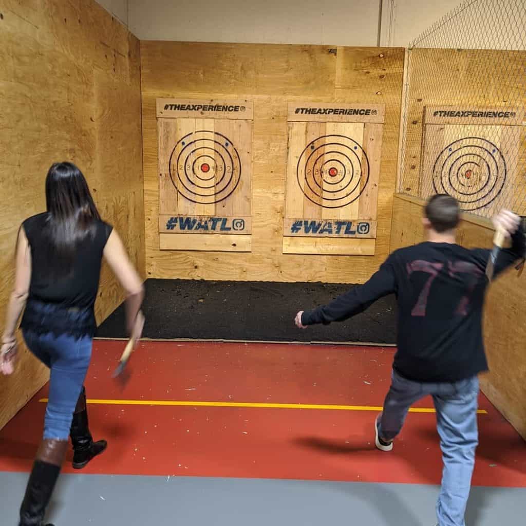 couple throwing axes at an indoor target