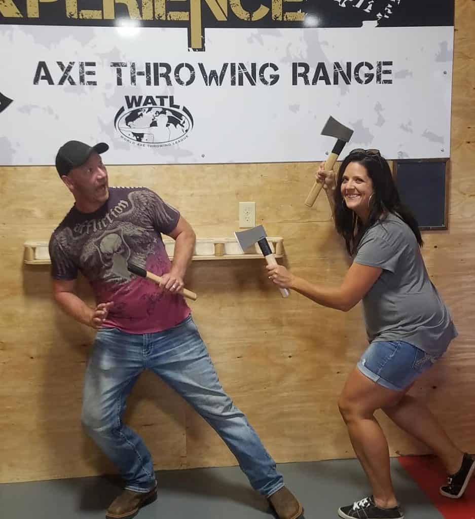 couple having fun at an indoor axe throwing range
