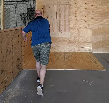 the AXperience founder Jon Finzen throwing at an indoor axe lane
